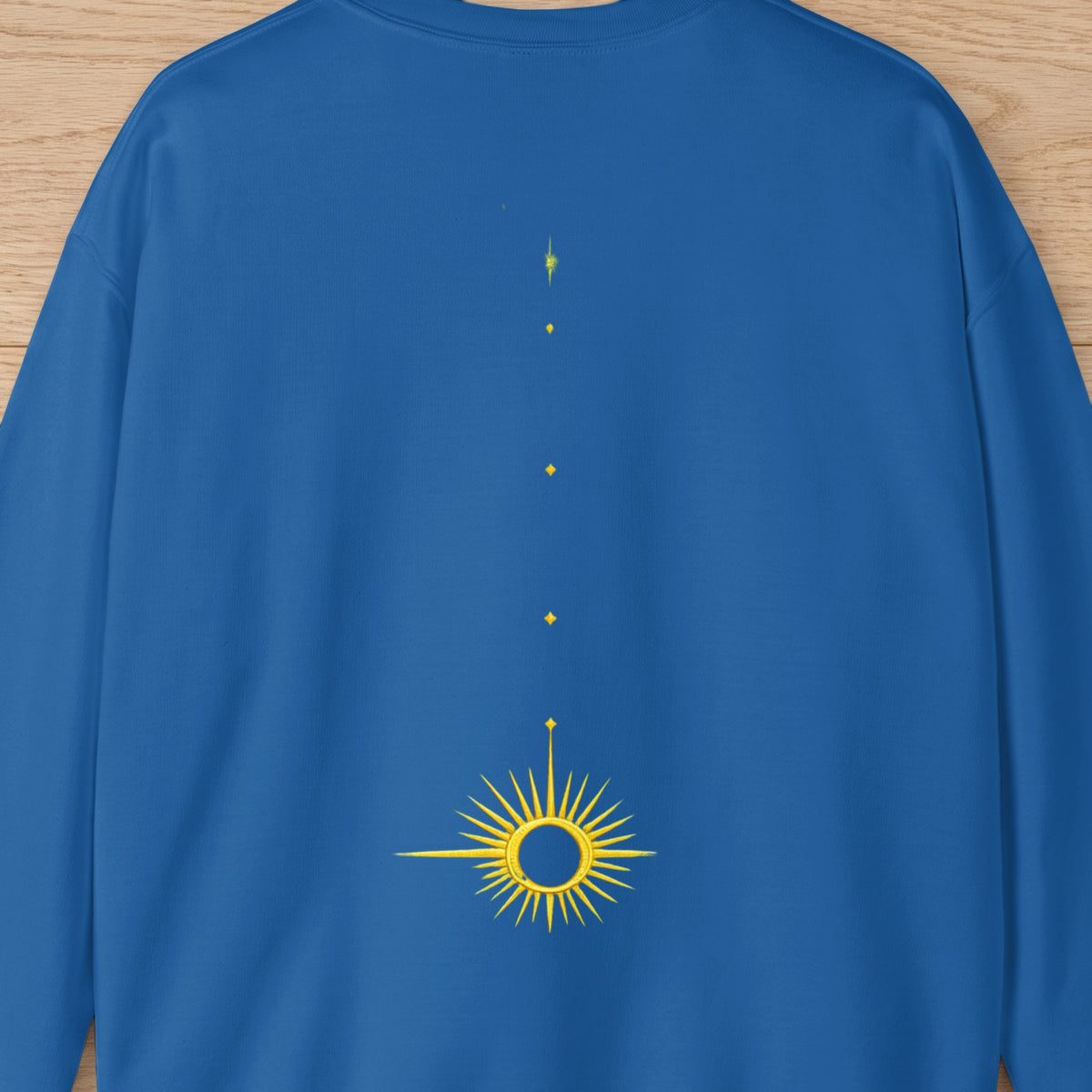 Blue sweatshirt with a yellow sunburst graphic and scattered dots.