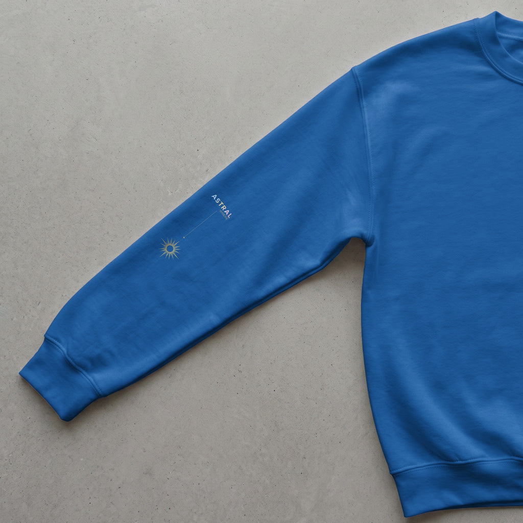 Blue sweatshirt sleeve with gold sun graphic and "ASTRAL WHERE" text.